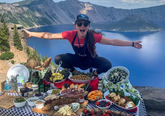 Leader standing above lunch table, gesturing to it.