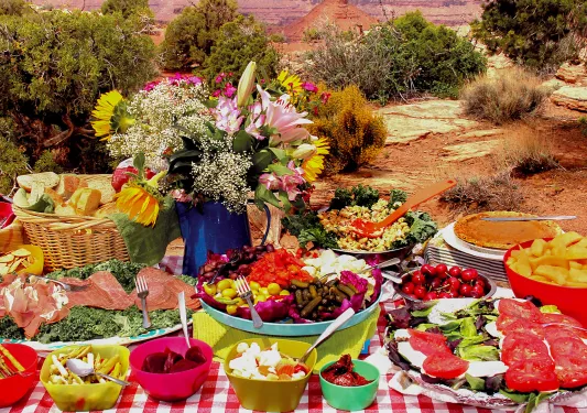 Picnic table spread with mountains in background 