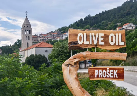 Shot of Croatian hillside town, Prosek, and 'Olive Oil" sign.