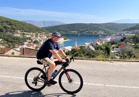 Guest cycling past Croatian riverside town.