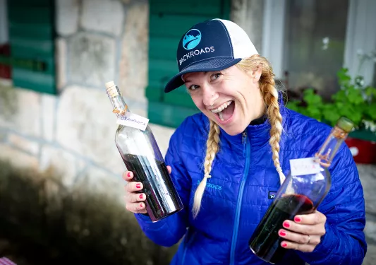 Leader with wine bottles, smiling at camera.