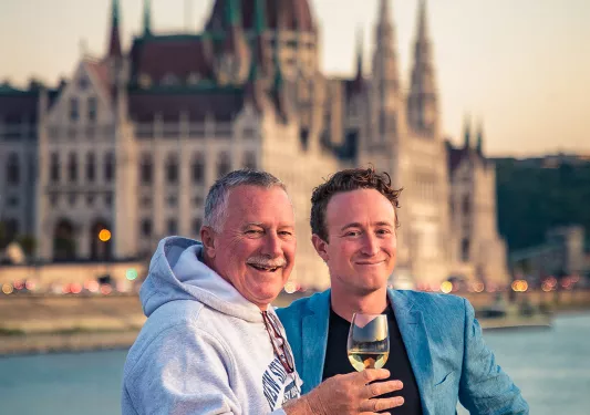 Two people hugging with glass of white wine in Budapest.