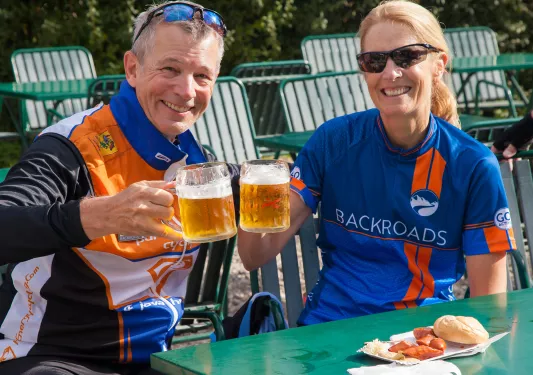Two bikers having beer and sausages.  