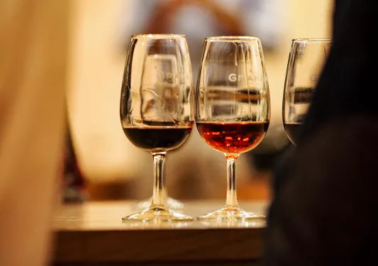 Three glasses of red wine on a table.