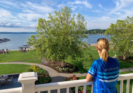 Guest standing on porch, looking out towards a large body of water.
