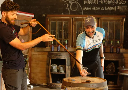 Guest with distillery worker, pouring sample.