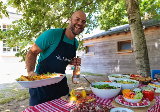 Leader prepping lunch spread, bottle of rose in hand.
