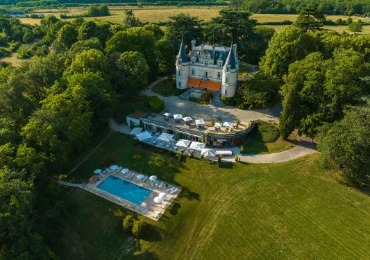 Bird's eye shot of Domaine de la Tortinière, pool, patio, surrounding trees.