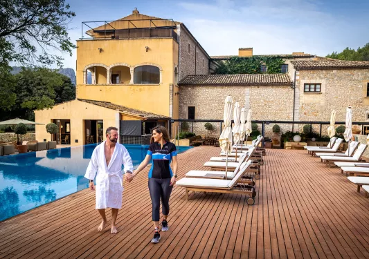 Two people holding hands poolside at a hotel in Mallorca / Menorca.