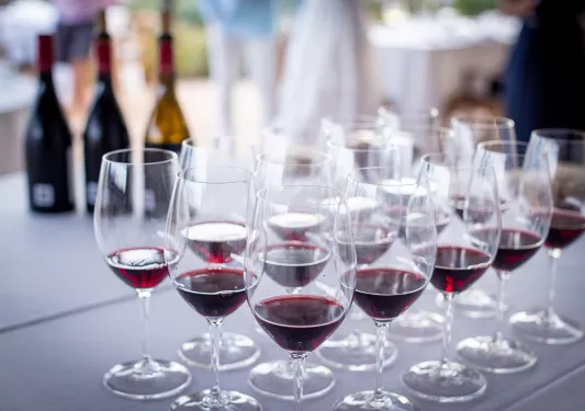 Table set with many glasses of red wine.