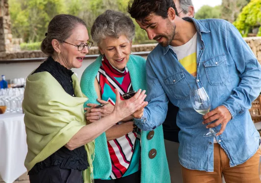 Three guests looking a phone.