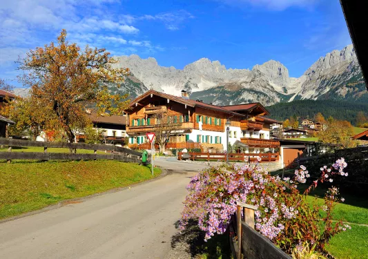 Wooden lodge hotel with mountains in background.