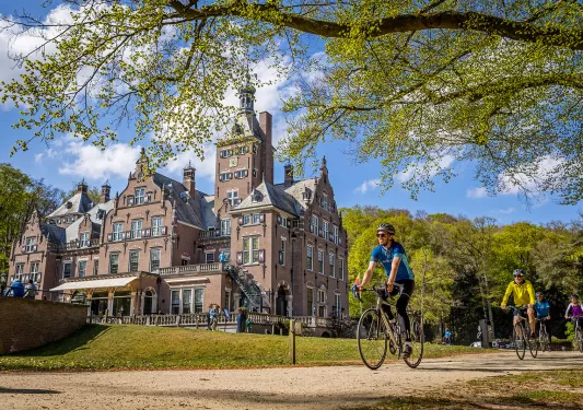 guests biking past beautiful building