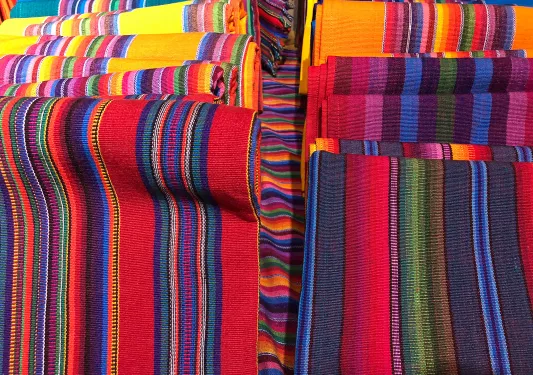 Colorful woven blankets rolled up