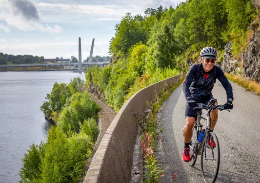 Biker riding along a river in Norway