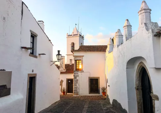 Walkway shot of white walled village during sunset.