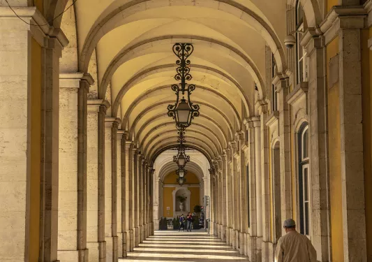 Hallway shot of numerous stone arches, chandeliers. 