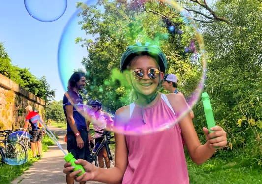 girl blowing a bubble and smiling