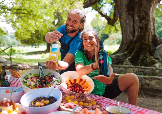 Leaders prepping lunch table, showing camera bottles of wine.