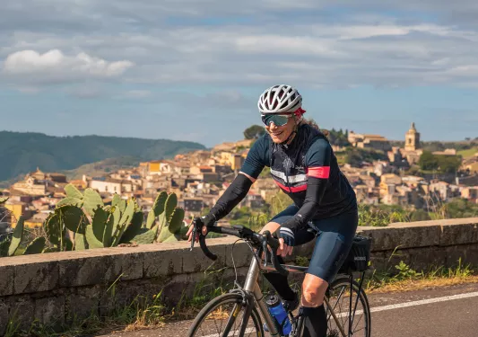 Guest cycling past mountaintop city.
