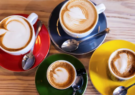 Close-up of four full coffee mugs.
