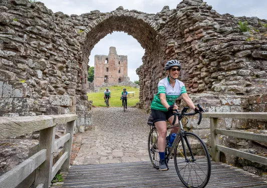 3 Guests Riding Cobblestone Under Old Arch Scotland