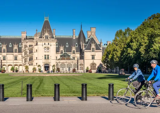 Guests biking in front of the Biltmore Estate.