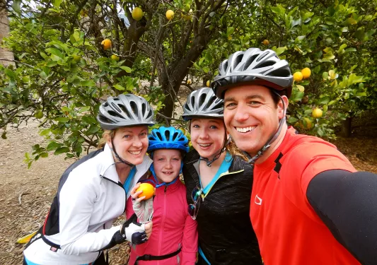 Four guests taking a selfie, orange tree behind them.