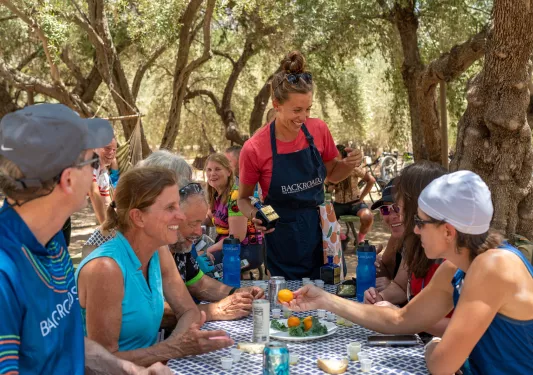 Guests at BR lunch underneath shady trees.