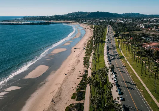 Wide shot of PCH in Santa Barbara, beach and ocean on left.
