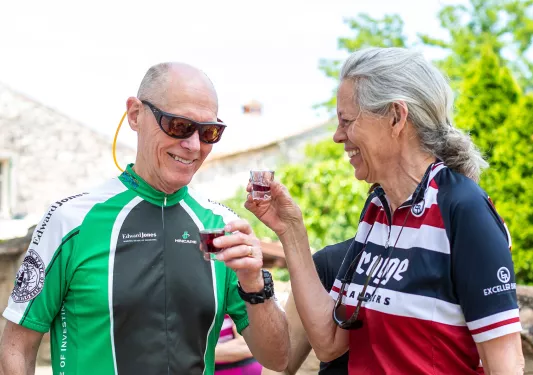 Two guests laughing and chatting in bike jerseys