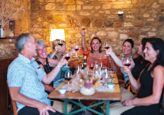 Group of guests at dinner, cheersing wine glasses.