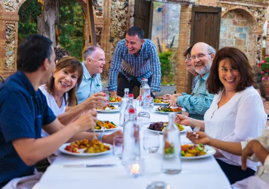 Group of guests at dinner, smiling and laughing.