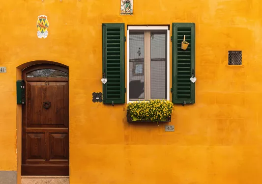 Shot of orange building, window, wooden door.
