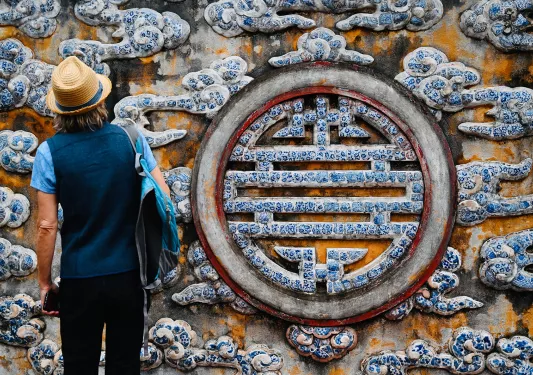 Guest in front of large painted longevity symbol.