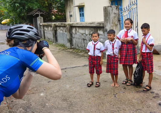 Guest/leader taking photo of four young locals. 