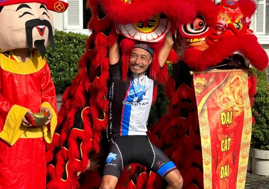 Backroads leader posing with a large dragon puppet in Vietnam