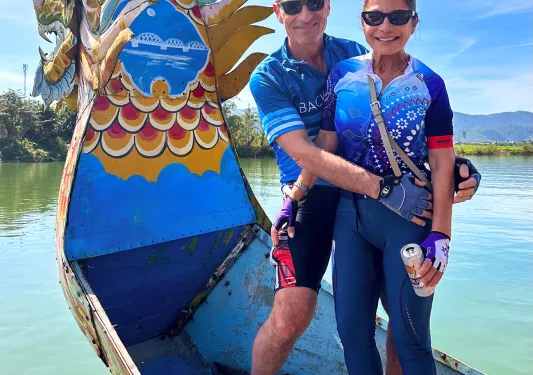 Two Backroads guests posing on a dragon boat in Vietnam