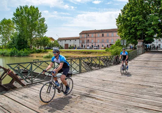 Cyclists crossing a wooden bridge in Veneto