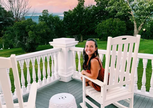 Guest on patio overlooking sunset, forest.