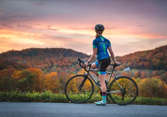 Guest with bike, looking out towards sunset in distance.