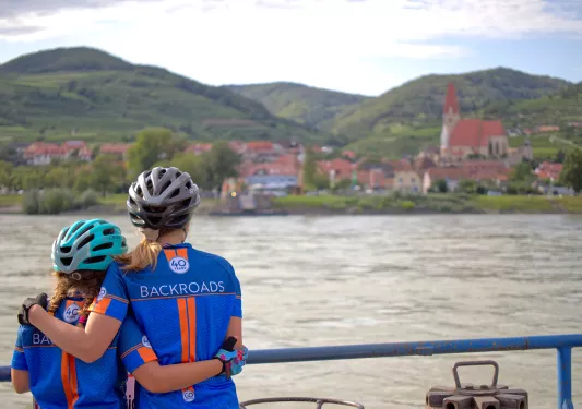 Adult and child posing together at boat deck overlooking Danube River.