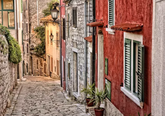 shot of stone and brick alleyway, colorful housefronts.