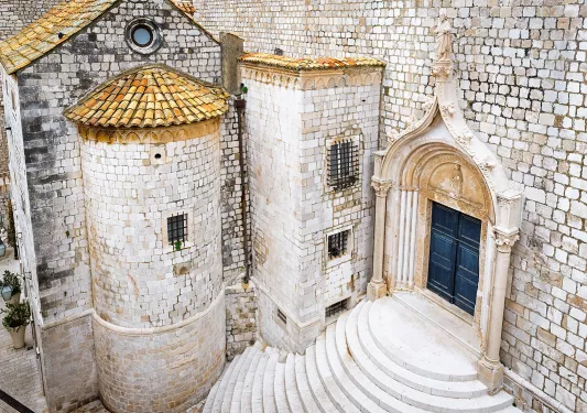 Shot of white stone buildings, staircase, doorway, etc.