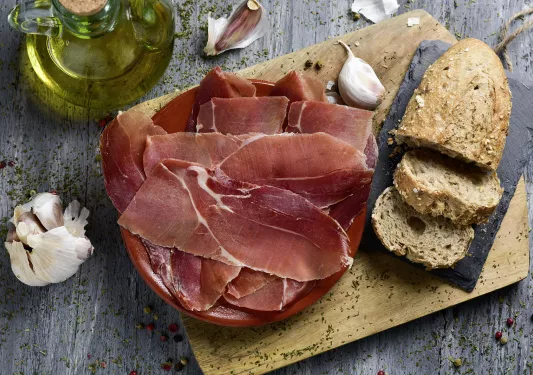 Plate of bread, cured ham, garlic, oil, etc.