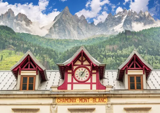 Train station clock at Chamonix Mont-Blanc, mountain in distance.