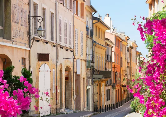 European alleyway lined with blooming bougainvillea flowers.