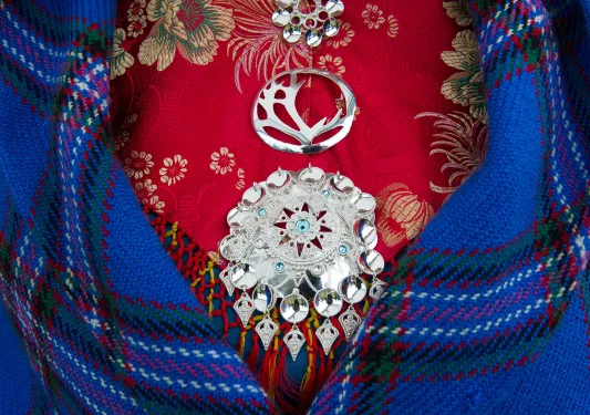 Front shot of colorful dress, medallions, blanket.