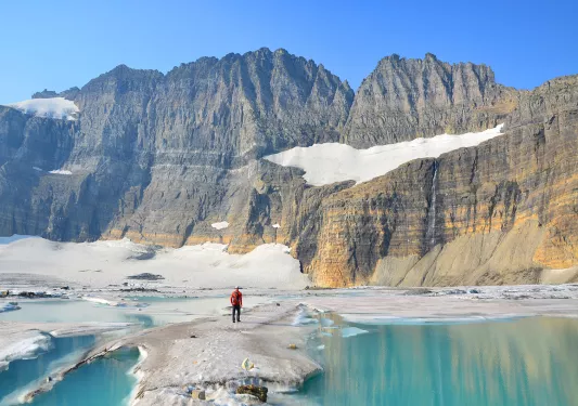 Aquamarine blue lake with snowy mountains and Backroads guest