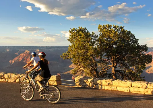 Two cyclists overlooking Grand Canyon.